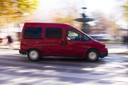 Red working vehicle at high speed in urban backgroundの写真素材