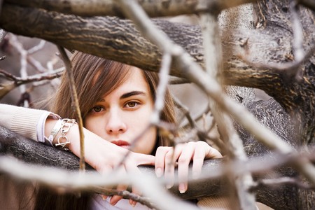 Young green eyed beauty between dead branchesの写真素材