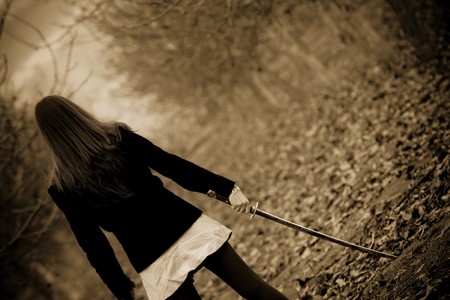 Young woman holding katana sword, sepia toned.の写真素材