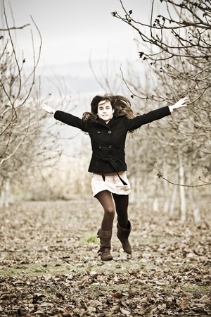 Young beautiful woman jumping in winter forest.の写真素材