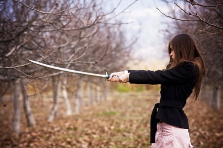 Young woman holding asian sword