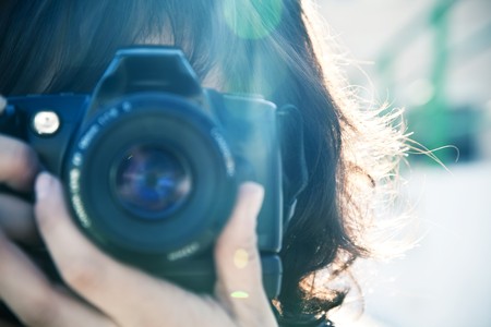 Female photographer under the sunlight. Focus on hair.の写真素材