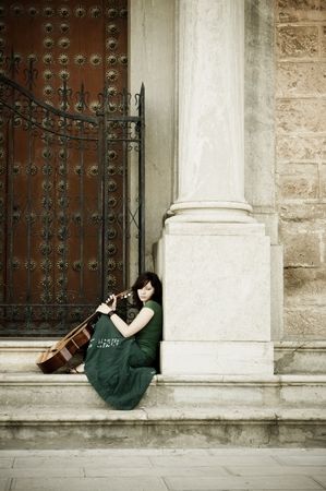 Lone street artist near old church door.の写真素材