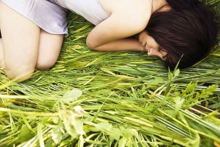 Beautiful girl sleeping over the grassの写真素材