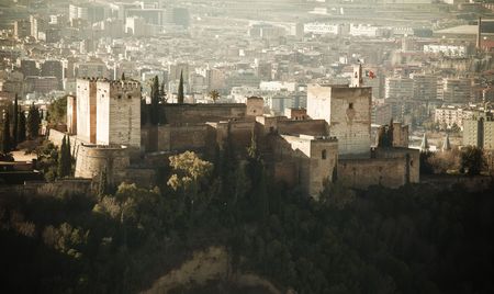 The Alhambra palace in its hill upon Granada city. Old style picture.