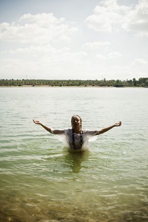 Young blond woman meditating in the water.
