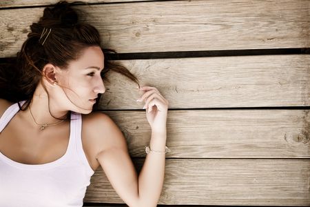 Young woman laying over wooden surfaceの写真素材