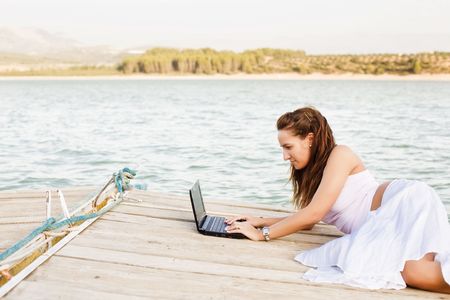 Young happy woman working with her laptopの写真素材