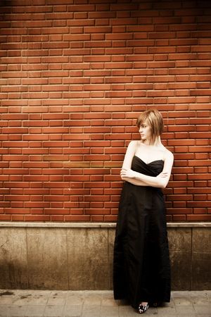 Beautiful blond woman elegantly dressed on wallの写真素材