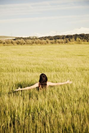 Young unrecognizable girl naked on meadow.の写真素材