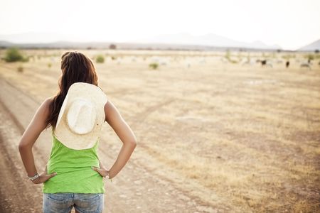 Young unrecognizable cowgirl watching her propertyの写真素材