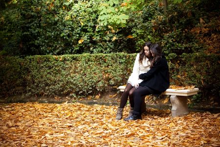 Sad female couple in beautiful autumn background.の写真素材