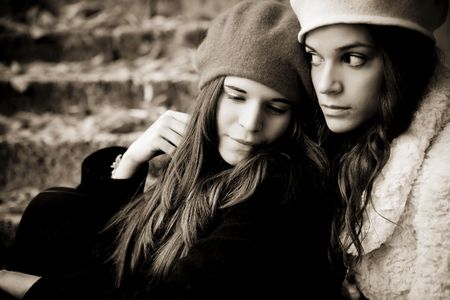Portrait of two sad girls, dark sepia toned.の写真素材