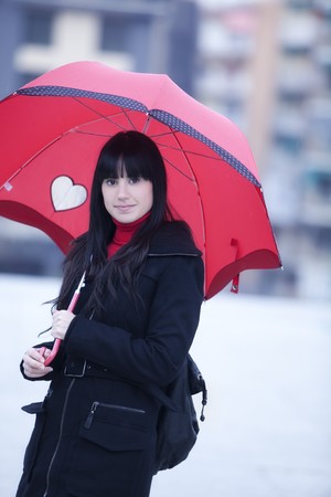 Girl hidden under umbrella while it´s rainingの写真素材