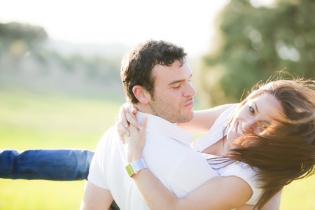 Young beautiful playful couple in action. Focus on him.