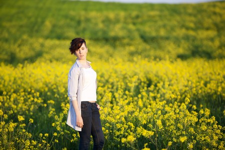 Young beautiful girl posing on a yellow field.