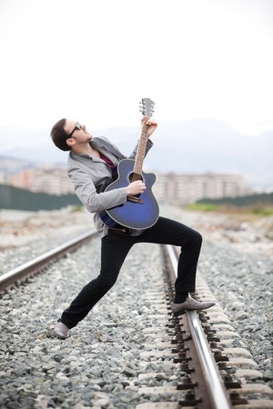 Young handsome musician singing outdoors.の写真素材