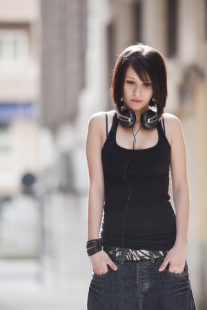 Young beautiful sad teen in urban backgroundの写真素材