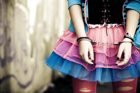 Handcuffs on young girl in modern dressingの写真素材