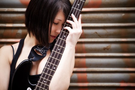 Young beautiful guitarist holding lovely her instrument.の写真素材