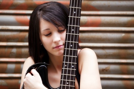 Young beautiful guitarist holding lovely her instrument.の写真素材