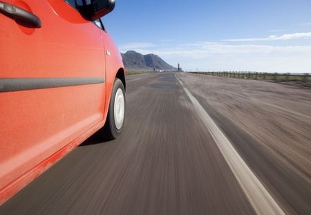 Red car driving through the country at high speedの写真素材