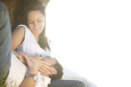 Young beautiful couple under tree, copy space composition isolated on white.の写真素材
