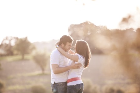 Young beautiful romantic couple in backlit compositionの写真素材