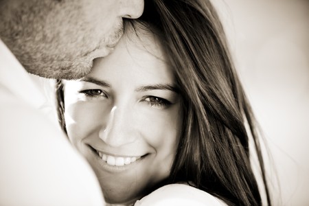 Young beautiful girl staring at camera while being kissedの写真素材