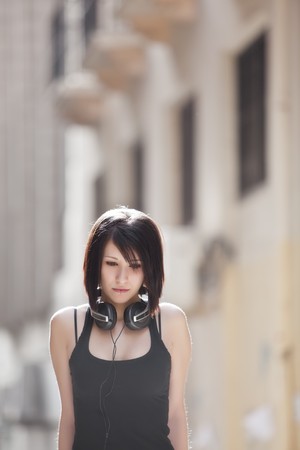 Young beautiful sad teen in urban backgroundの写真素材