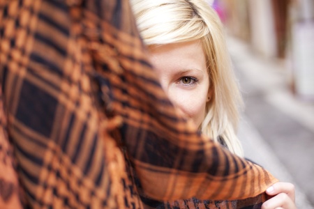Young beautiful blonde hidding behind arabic headscarf.の写真素材