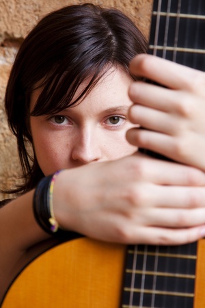 Woman holding guitar, focus on face.の写真素材