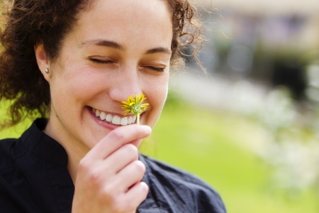 Young beautiful curly woman smelling and smiling.の写真素材