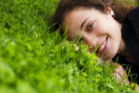 Young happy girl smiling at camera over the grassの写真素材