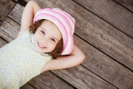 Pretty child lying on wooden surface.の写真素材