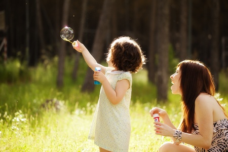 Young mother and her child playing with soap bubblesの写真素材