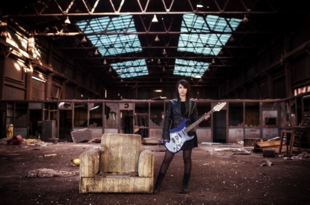 Young beautiful performer posing with her electric guitar.の写真素材