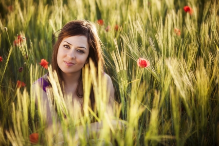 Young beautiful girl posing in a green field.の写真素材