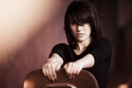 Young woman portrait showing attitude sitting on a chair.の写真素材
