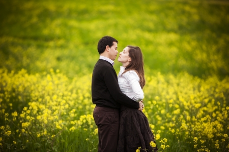 Young loving couple showing their love on a green fieldの写真素材