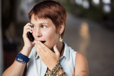 Beautiful girl being surprised by a callの写真素材