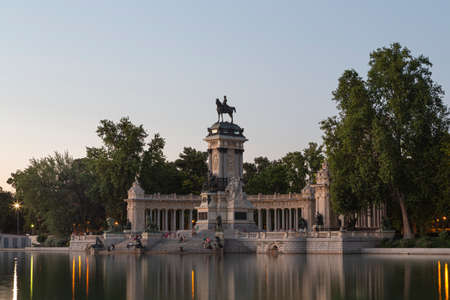 People sitting at sunset on the steps of the big pond del Buen Retiro in Madrid, Spainの写真素材