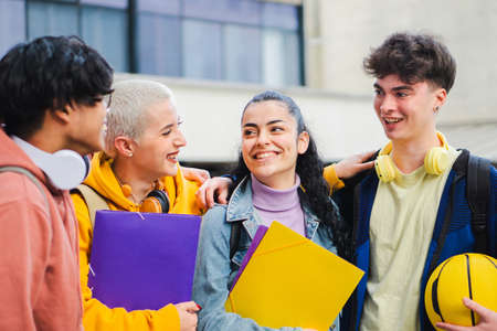 Young students laughing at the university buildingの写真素材