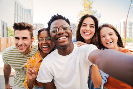 Group of multiracial young student people smiling and taking a selfie together. Close up portrait of happy african american teenager laughing with his cheerful friends. Classmates on friendly meetingの写真素材