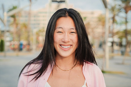 Close up individual portrait of happy asian young adult woman smiling with perfect white teeth....