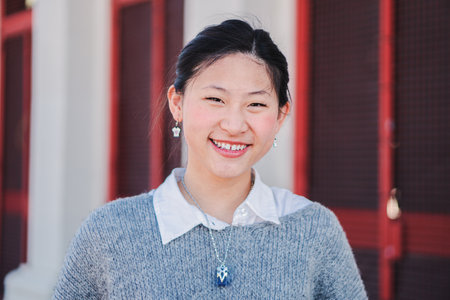 Close up individual portrait of happy chinese young adult woman smiling and looking at camera. One teengage school girl staring front with friendly expression and white teethの写真素材