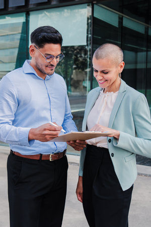 Vertical portrait of two business people working and cooperating together. Successful saleswoman...