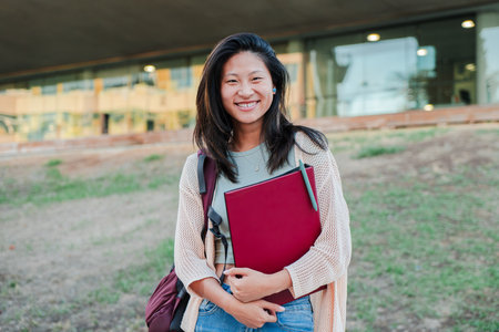 Portrait of a chinese school girl smiling and looking at camera. Asian young brunette woman staring...