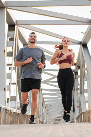 Vertical. Young couple running for health, wellness or training for a marathon, competition or race,...