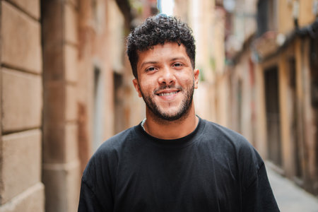 Close up individual portrait of one arab male smiling and looking at camera outside. Young adult arabic guy staring front and laughing with friendlyの写真素材